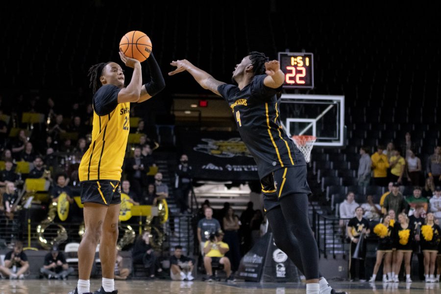 Sophomore Shammah Scott shoots a 3-pointer while  his teammate, junior, Colby Rogers, defends him during Shocker Madness on Oct. 27 at Charles Koch Arena.