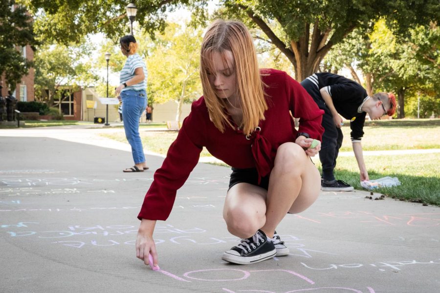 Elly Gordon of FOCUS writes messages advocating for abortion rights, womens rights, and LGBTQ+ rights. The messages were written on the sidewalk of the RSC North patio.