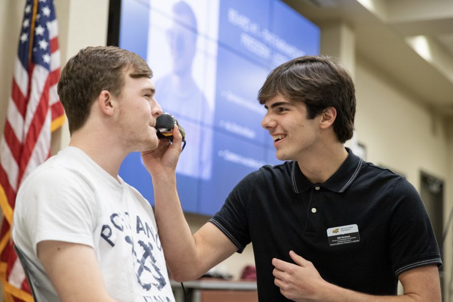 Logan Hutchens, computer science major, lets Will Dirnbeck, director of scholarship and retention with the Interfraternity Council, shave his beard.