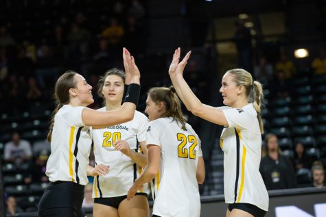Kayce Litzau and Morgan Stout high five after they earn a point against Grand Canyon University on Dec. 4.