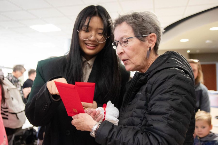 WSU student Wang Yang Jinyi and her teacher discuss about the red envelopes that were handed out from the Lunar New Year event.