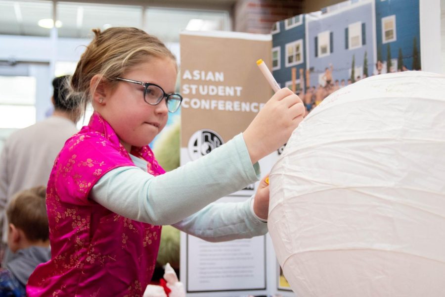 Event goer writes a message on the paper lantern for Lunar New Year set out by WSU Asian Student Conference.
