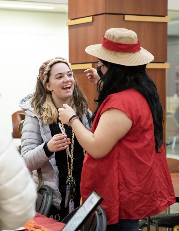 Secretary of Society of Cosplayers Sydney Burtwistle and Vice President of Spectrum and President of Society of Cosplayers Damarís N. Mireles hug while holding tables during Springfest. Different organizations and clubs tabled at the event on Jan. 24.