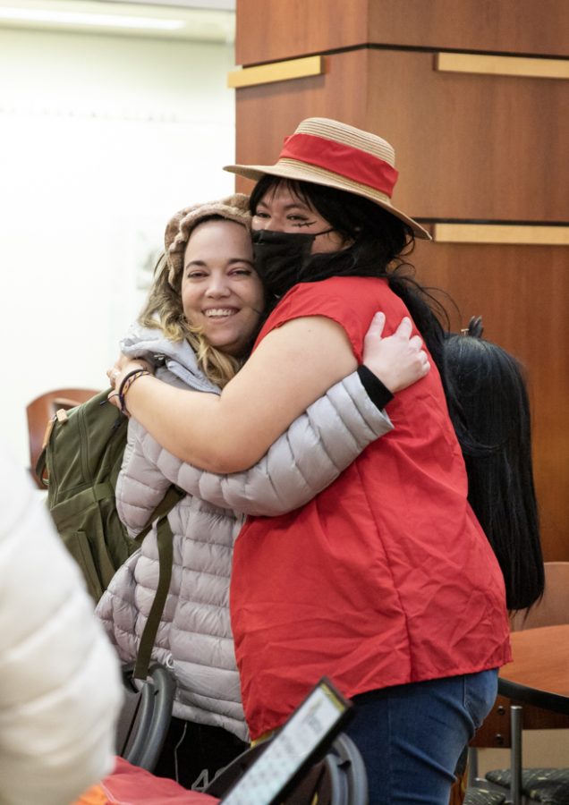 Secretary of Society of Cosplayers Sydney Burtwistle and Vice President of Spectrum and President of Society of Cosplayers Damaris N. Mireles hug while holding tables during Springfest. Different organizations and clubs tabled at the event on Jan. 24.