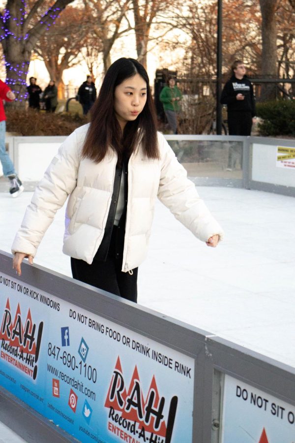 A novice skater holds to the side of the rink to maintain her balance while skating at the Winter Welcome. The artificial rink was rented for the event by Record-a-Hit Entertainment.
