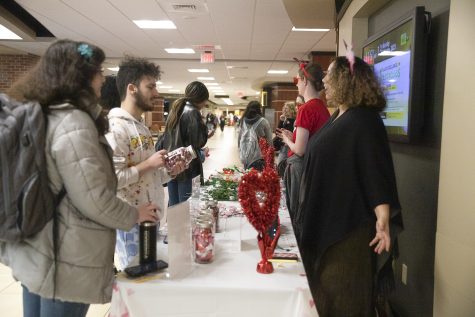 Students Phoebe Batten and Othman Alfraih attempt to count the number of candies in the jar while talking to Landyn Patterson, marketing coordinator at WSU. “Nothing is Sweeter than Meeting Admin” took place on Feb. 13 and encouraged students to get to know administration at WSU.