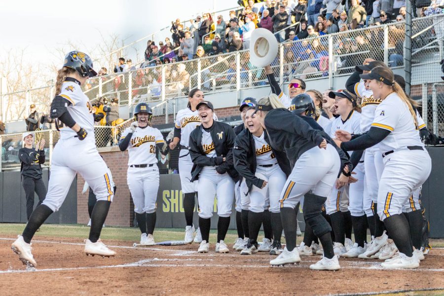 Sydney McKinney (#25) is welcomed back to home plate by her fellow Shockers. The team cheers, laughs and celebrates after McKinneys hit.