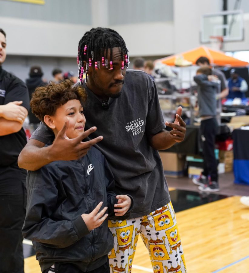DAydrian Harding poses with a kid during the Kansas Sneaker Fest on March 25. Harding, a popular creator on TikTok, hosted the event in Charles Koch Arena.
