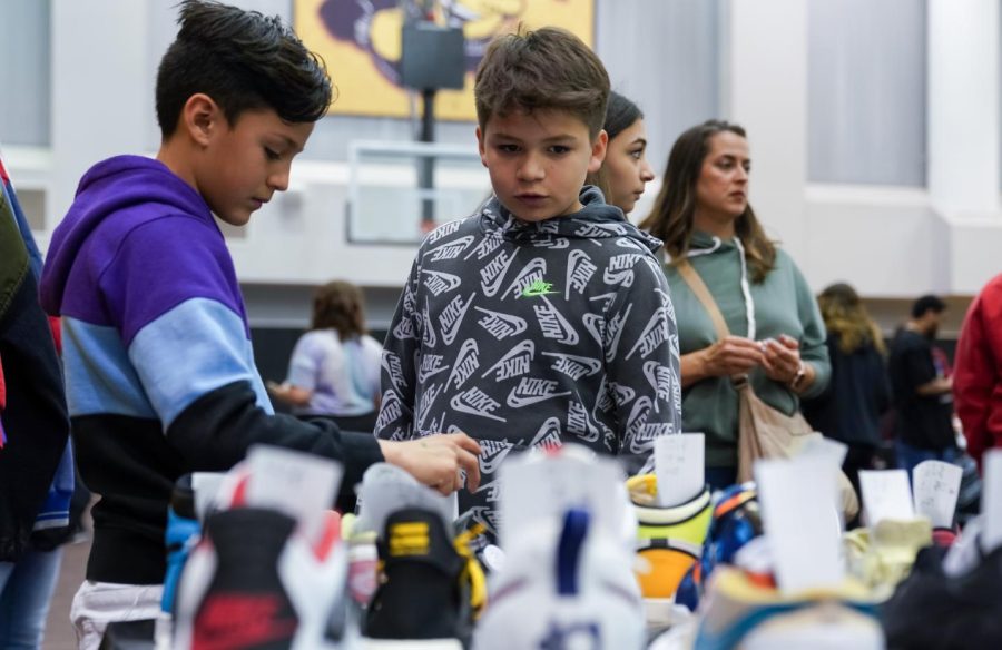 Children look at sneakers during the Kansas Sneaker Fest. The event was a convention for sneaker enthusiasts to trade, sell and buy in Charles Koch Arena on March 25.