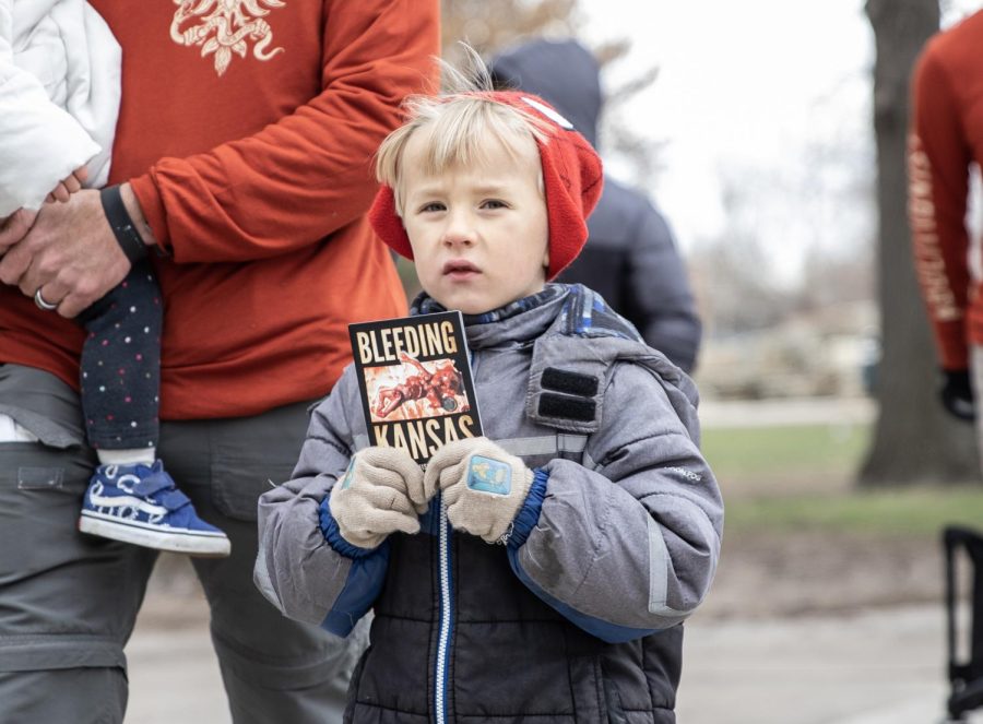 A child carries an anti-abortion information card while walking in protest of abortion on March 2.