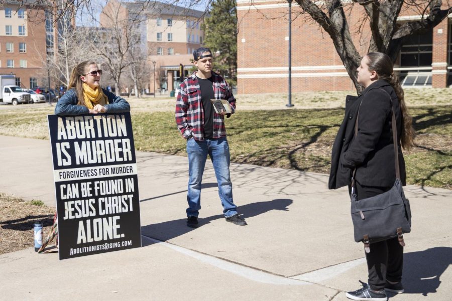 Anti-abortion protesters show their signs to people on Wichita States campus. The group, Free the States, protested on March 3.