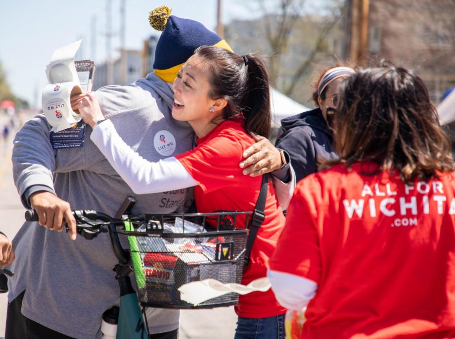Lily Wu hugs a passerby while they discuss matters of the city. Wu, 2023 mayoral candidate, and her team organized a booth at ICT Open Streets on April 16 to gain more publicity and to listen to the citizens of Wichita.