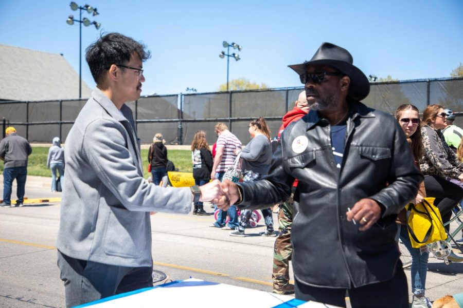 Vuong shakes hands with a local after discussing the importance of young people getting into politics. Vuong discussed how USD 259 could improve education and schools by having the community write them down on paper.