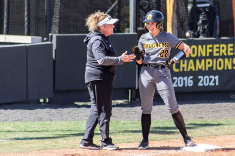 Lauren Lucas talks to head coach Kristi Bredbenner after hitting a three-RBI triple in 2023. Lucas missed all of last season with an injury.