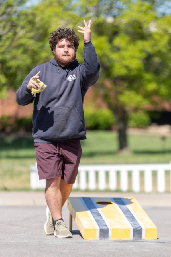 One participant of Saturdays Cornhole Tournament throws a bag. The event was hosted by Human Performance Studies (HPS), a student organization on campus.