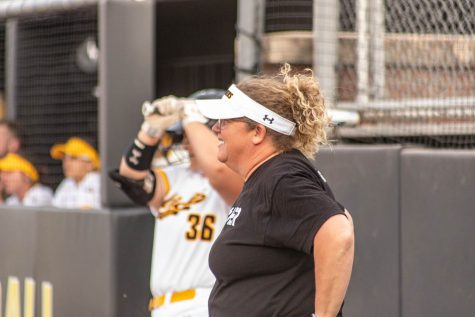 Head Coach for the Shockers softball team, Kristi Bredbenner stands by the dugout in the second inning of a game in April 2023.