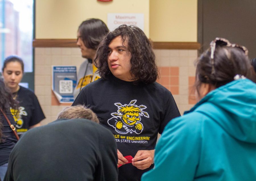 A WSU student assists families signing into the event. Noche de Ciencias took place on March 30.