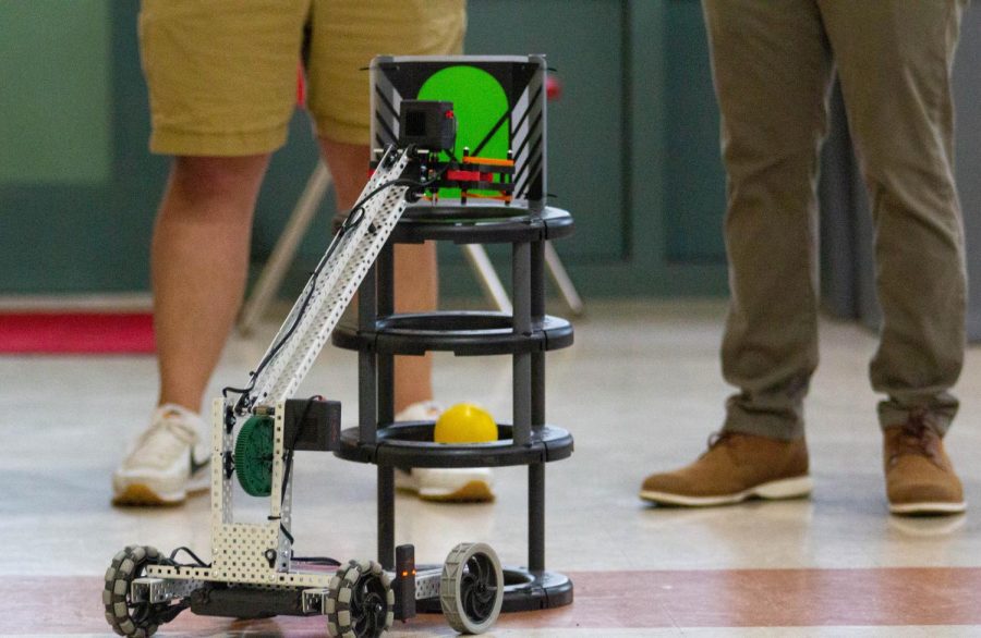 A robot from VEX robotics that is controlled by a student drops a ball into a hoop at the Noche de Ciencias event on March 30.