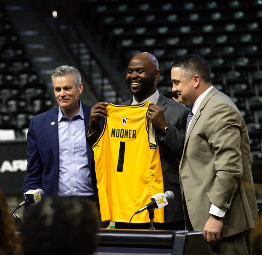 New head womens basketball coach Terry Nooner holds up his new jersey given to him by university president Rick Muma and athletic director Kevin Saal at the press conference in Charles Koch Arena on April 20.