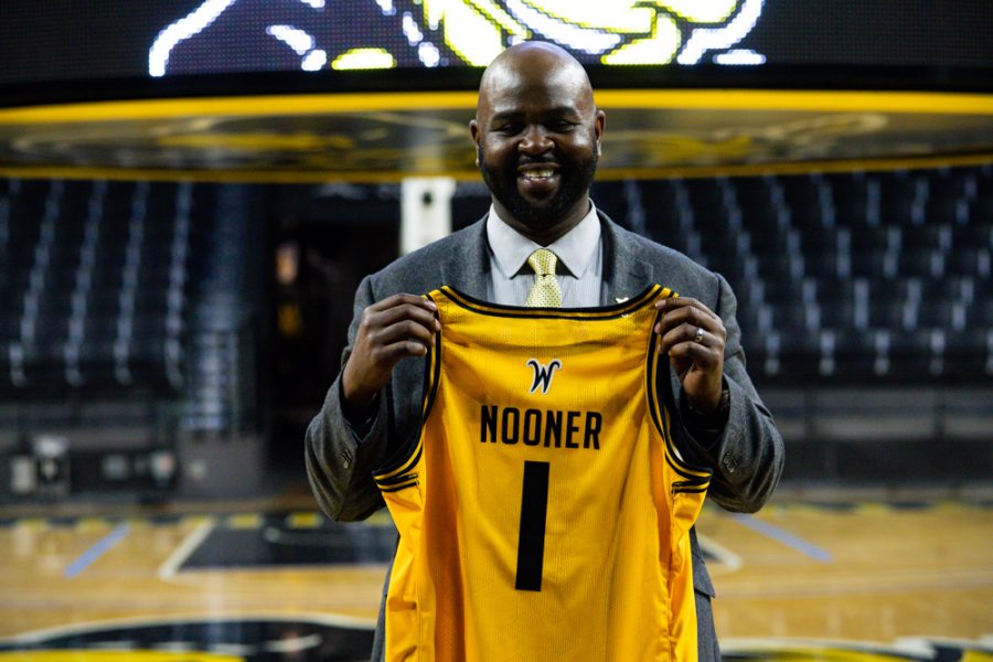 New head womens basketball coach Terry Nooner holds up his new jersey given to him by President Numa and Athletic Director Kevin Saal at the press conference in Charles Koch Arena on April 20.