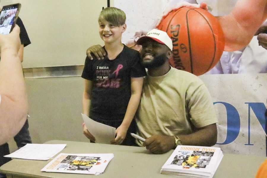 Wichita State alum Shaq Morris poses for a photo with a child after the Wichita SkyKings game on May 28. The game and FanFest after was held in hopes of breaking attendance records.