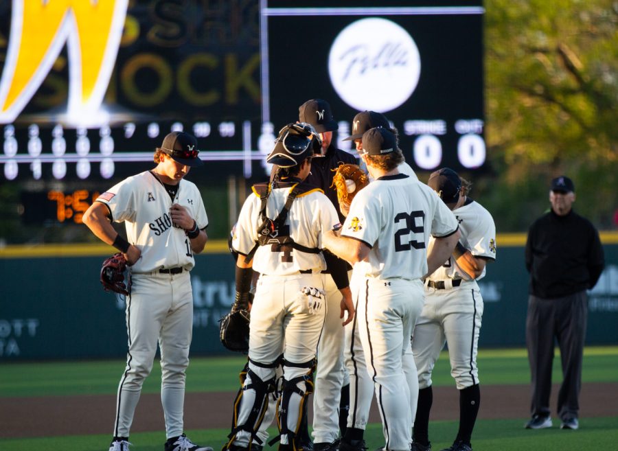 The team meets at the pitchers mound during their matchup against Kansas State.