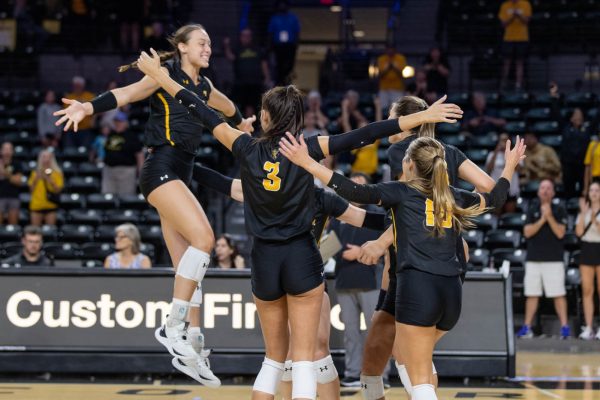 Morgan Stout leaps to her teammates after the team scored the 15th point in the final set. The team came together to celebrate winning the first game in the Oklahoma exhibition match.