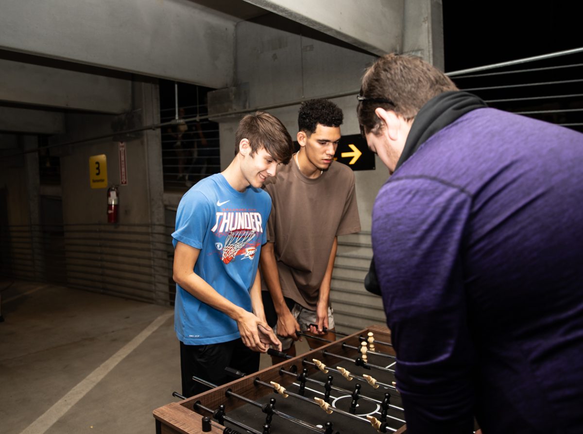 Freshman Cameron Burrows plays foosball with other attendees, one of the many activities offered at the garage party.