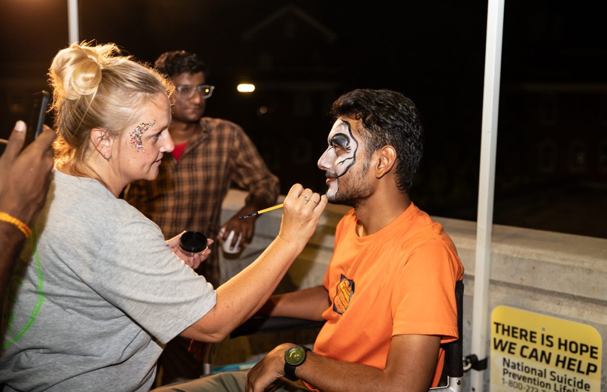 A student sits for a face painter at the back-to-school event.