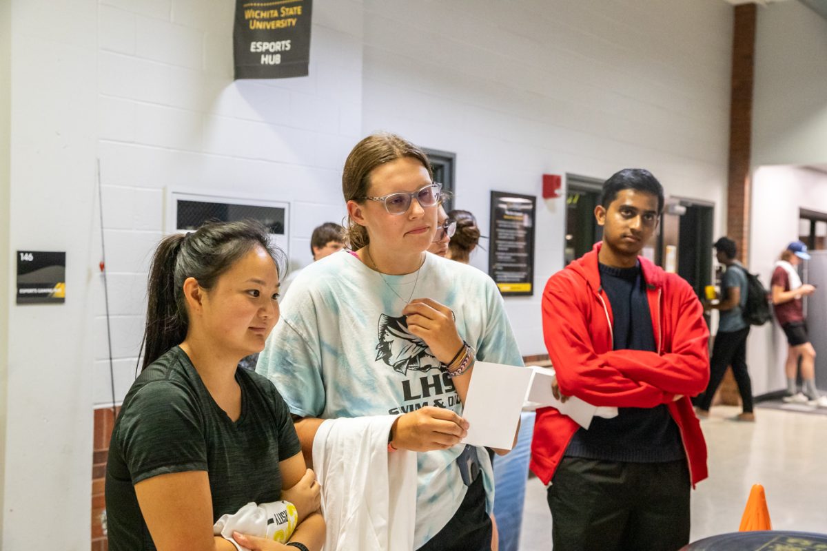 Wichita State students ask question to frisbee stall staff at RecFest in the Heskett Center on Aug. 22.