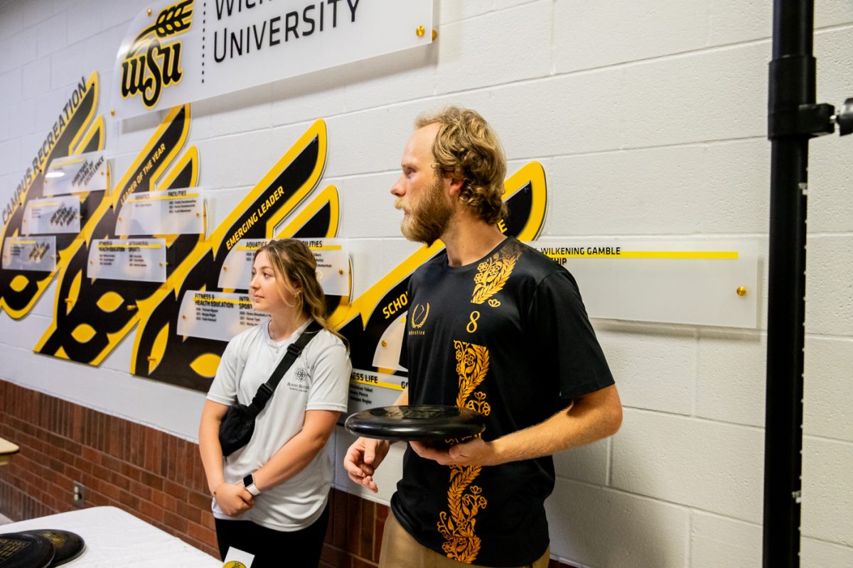 Frisbee stall members listen to students questions at RecFest.