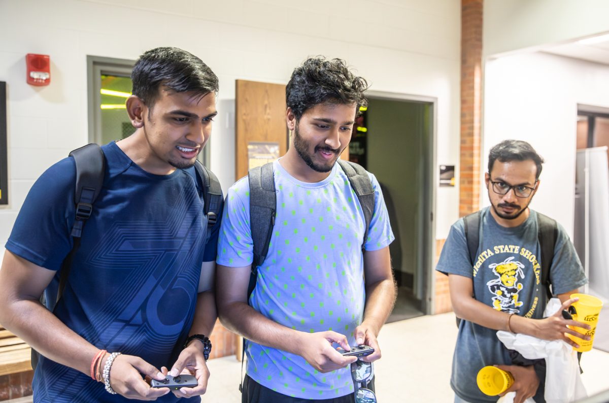 Graduate students Shivaam Pawar and Bharath Reddy play a Mario Bro. game at the gaming club stall at RecFest on Aug. 22.