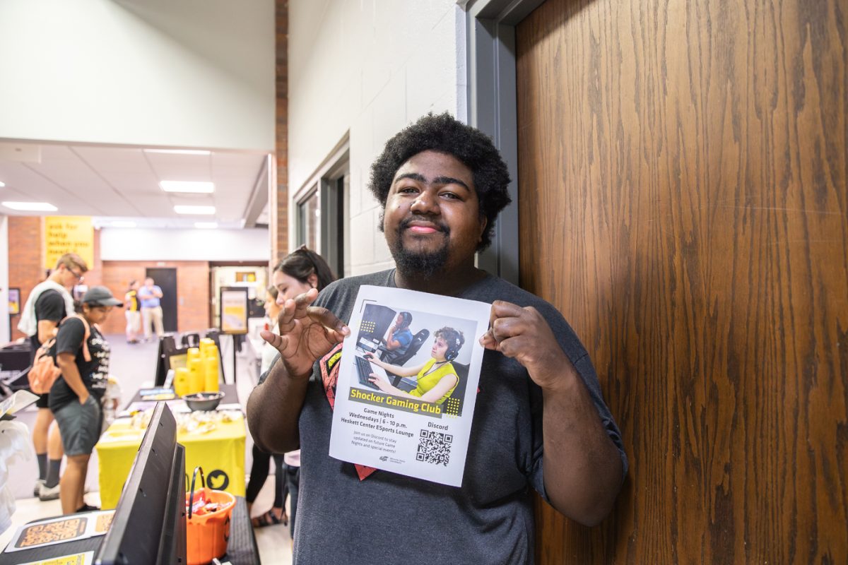 A Shocker Gaming Club member shows their flyer to students at the RecFest on Aug. 22.
