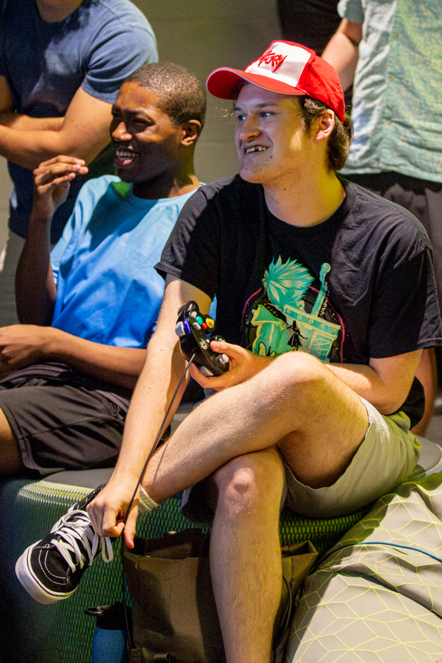 Jayce Lamb, a filmaking major, sits amongst the group as he plays a round on the big screen. The freshman played a round of Super Smash Bros Ultimate at Aug. 23 Esports Hub Open House.