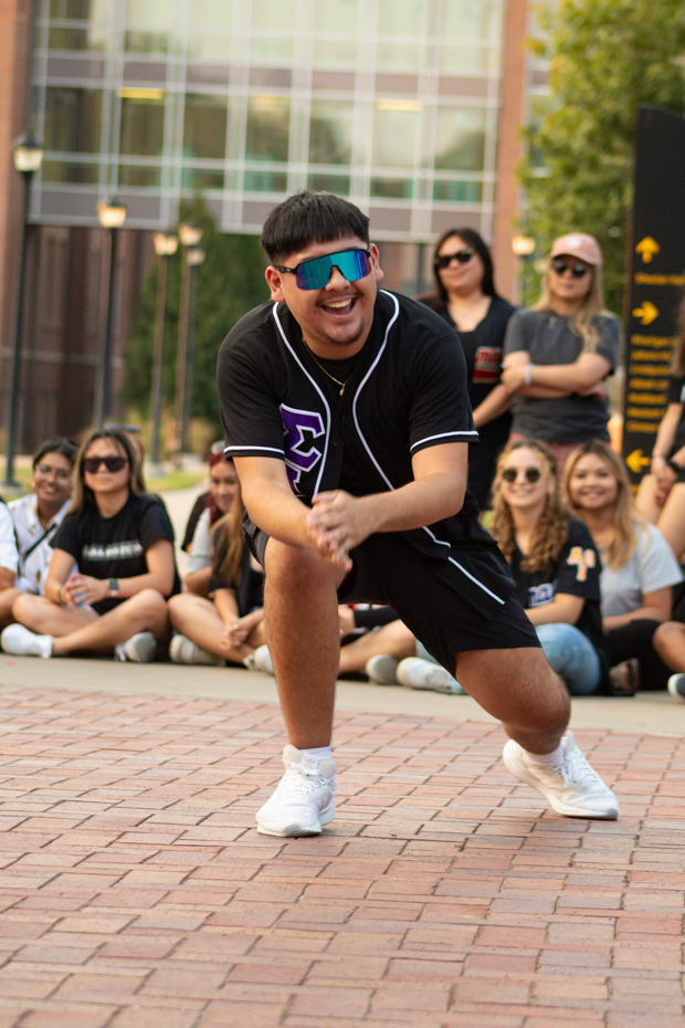 Jazciel Zapata leans down towards the crowd while performing. He performed with Sigma Lambda Beta.