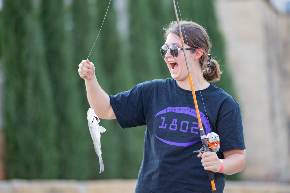 Elise Collins celebrates after catching a fish at the Smores and Oars event hosted by Shocker Rowing. This was the Wichita State freshmans first catch in years.