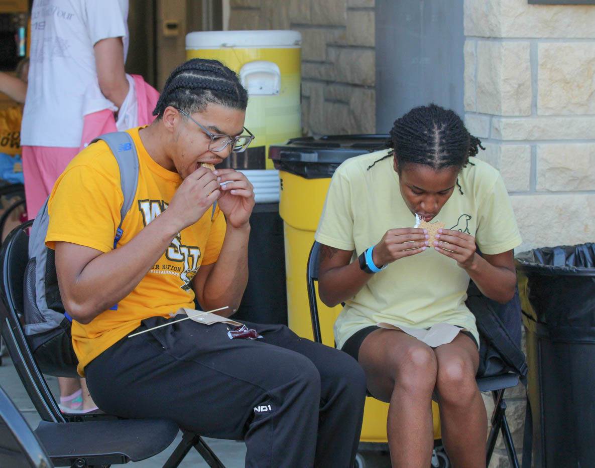 Two students enjoy the smores provided by the Shocker Rowing team at their first event of the year, Smores and Oars. Along with a fun treat, there were fun games and different water sports they could partake in on Aug. 30.