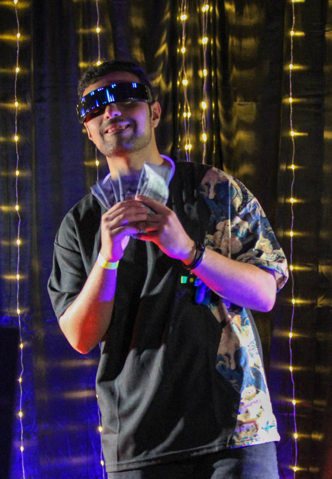 A student poses with fake money at the photo booth. The Glow Party, an event hosted by the Student Activities Council, took place in the RSC on Aug. 31.