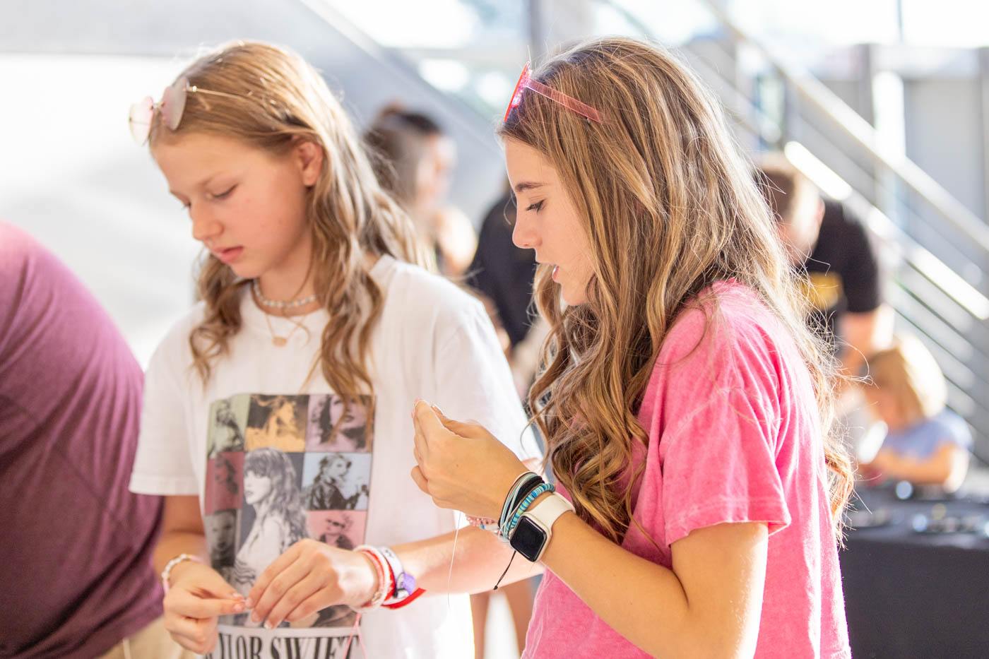 MacKenzie and Addison create friendship bracelets at the Taylor Swift tailgate in Koch Arena on Sept. 9. MacKenzie said her favorite Taylor Swift era is Reputation.