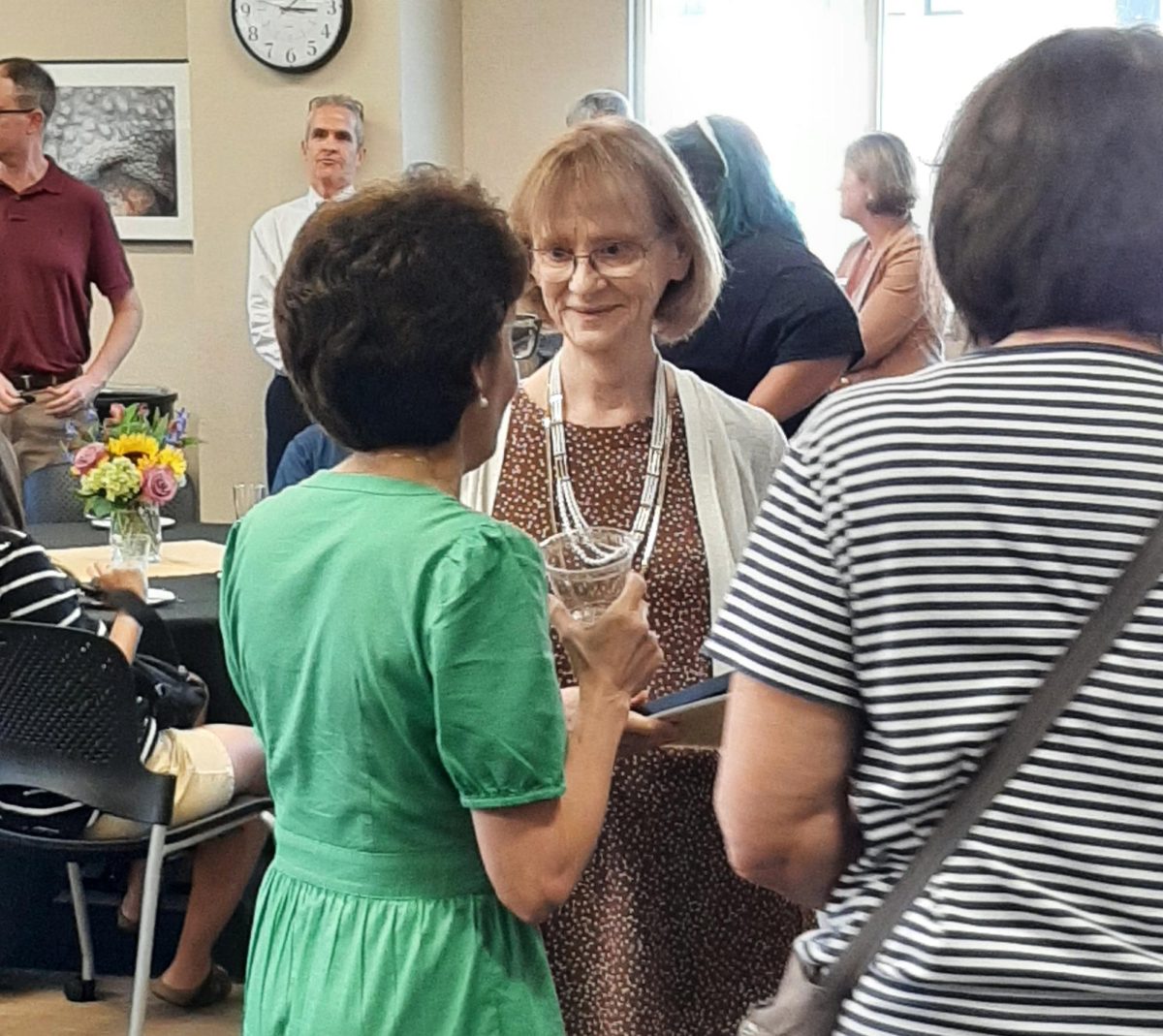 Kathy Downes, retiring dean of university libraries, speaks with a guest at her retirement reception on Aug. 31.