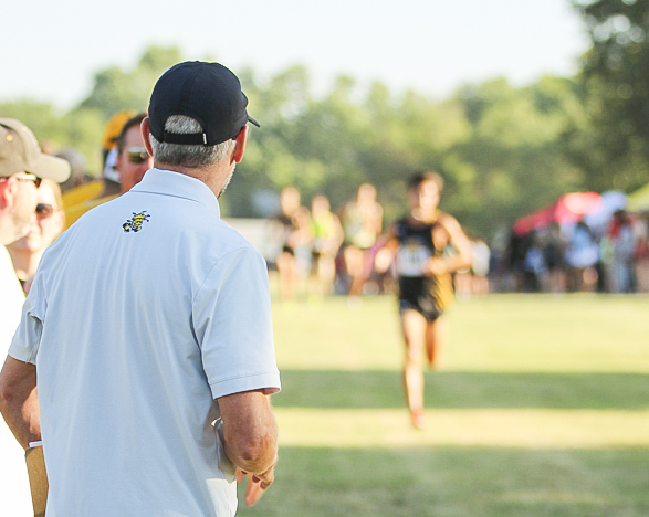 Director of Operations Roger Shurtz watches the mens cross country runners finish out the meet at the JK Gold Classic on Sept. 2.