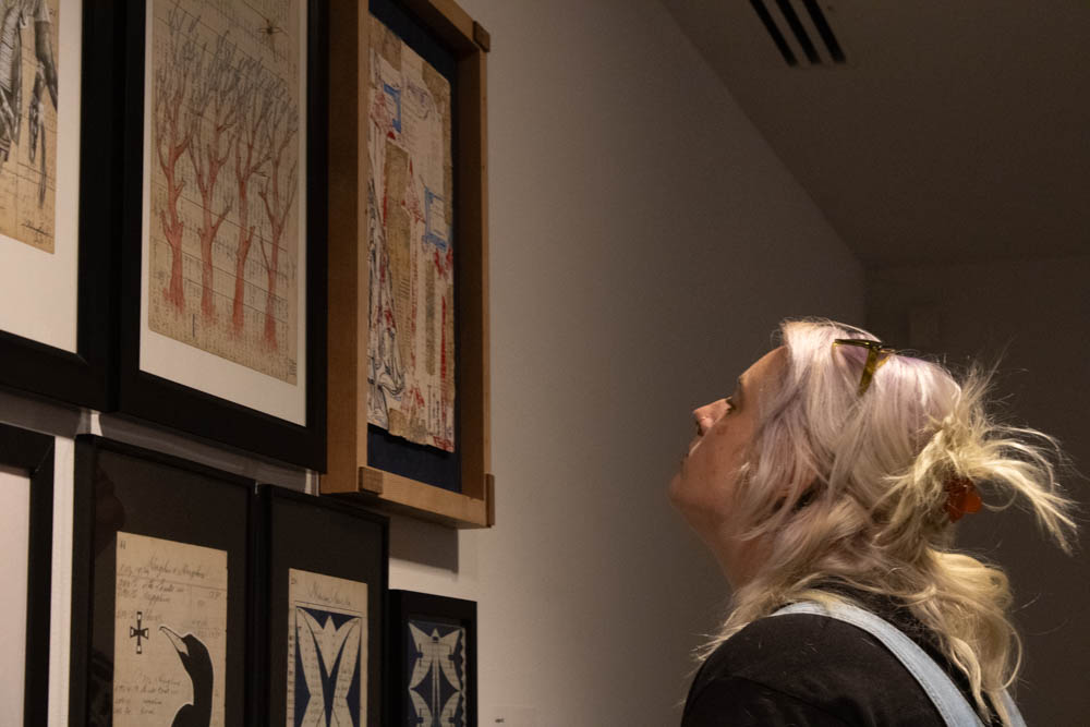 Community member Allison Sutton gazes at ledger art by local artists for the Twice Removed exhibition on Sept. 8.
