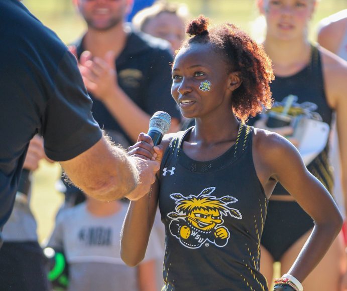 Lucy Ndungu, newcomer and one of Wichita States top runners pronounces her name to the audience at the JK Gold Classic meet at Clapp Park. Ndungu finished in first place  with a time of 17:42.5 in the 5k.