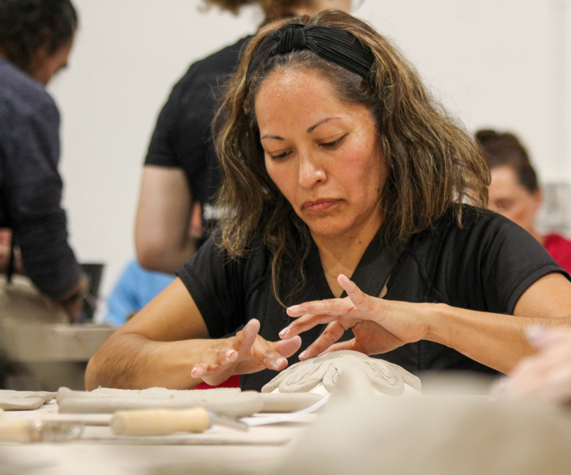 Esther Herrera joins her daughter in hand-building a bowl at the Ulrich Build-A-Bowl event. Herrera came to the event after seeing it advertised on Facebook.