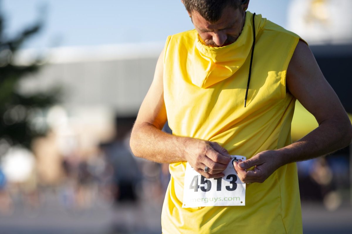 Eric Thomas, 40, attaches his race number to his clothes before the start of the Suspenders4Hope 5k on Sept. 30.