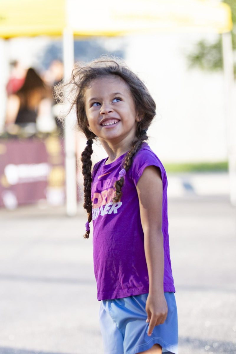 Stella, the daughter of CAPS counselor Annette Santiago, smiles at her family before the start of the Suspenders4Hope 5k on Sept. 30.