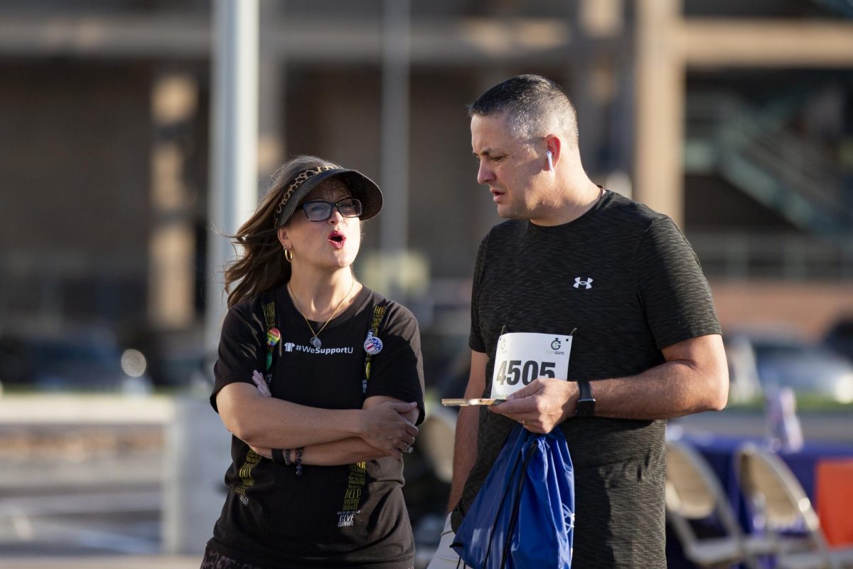 Jessica Provines, assistant vice president for wellness at CAPS, speaks to Kevin Saal, athletics director at WSU, before the start of the Suspenders4Hope 5k. This was the third year the 5k as well as a one-mile memorial walk had been held at Wichita State.