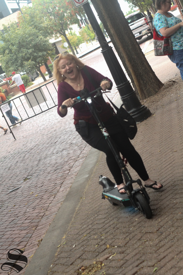 Alexandra Wolf takes one of wichitas scooters out for a joyride around the edge of the garlic fest grounds.