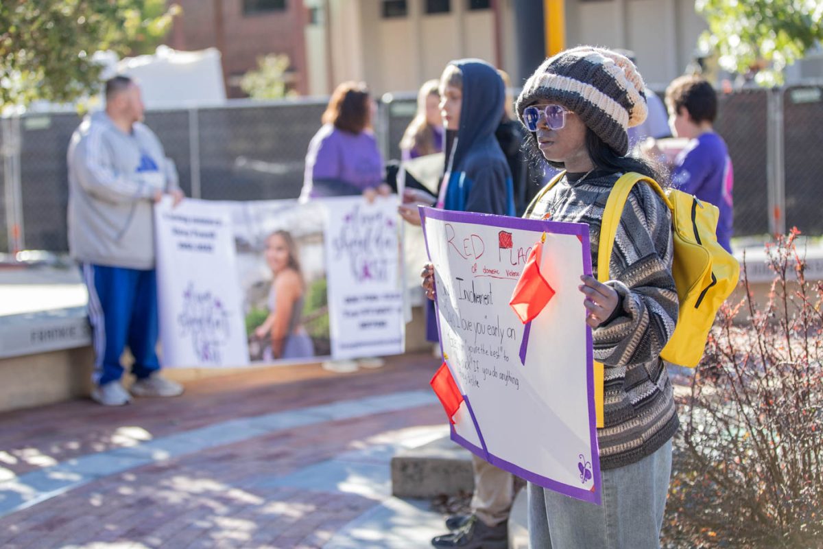 Students from Coleman Middle School hold signs sharing specific stories and red flags during the moment of silence. The students are a part of the World Changers club at their school, where they advocate for many social issues including domestic violence.