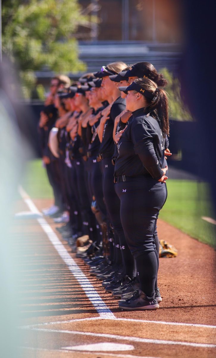 Wichita State softball players stand in a line during the national anthem on Oct. 7.